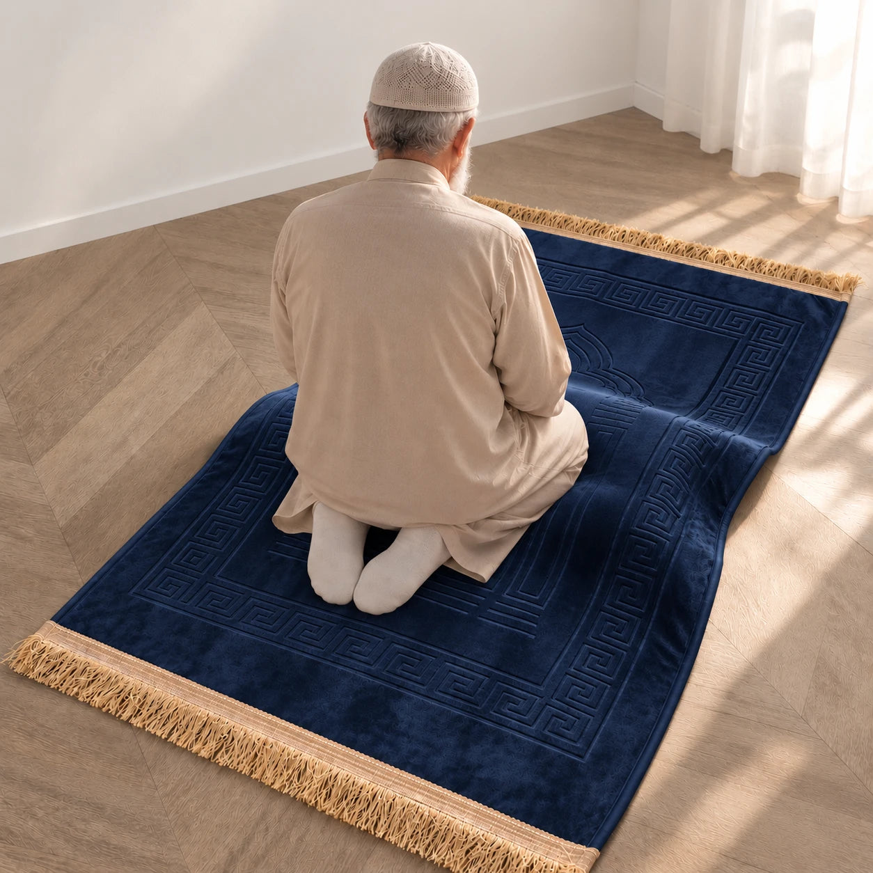 Homme âgé assis en position de repos sur le tapis de prière Baraka bleu marine