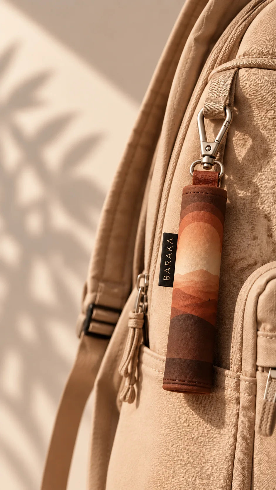 La pochette du tapis de prière nomade Baraka, clipsée à la poche d’un sac à dos en toile