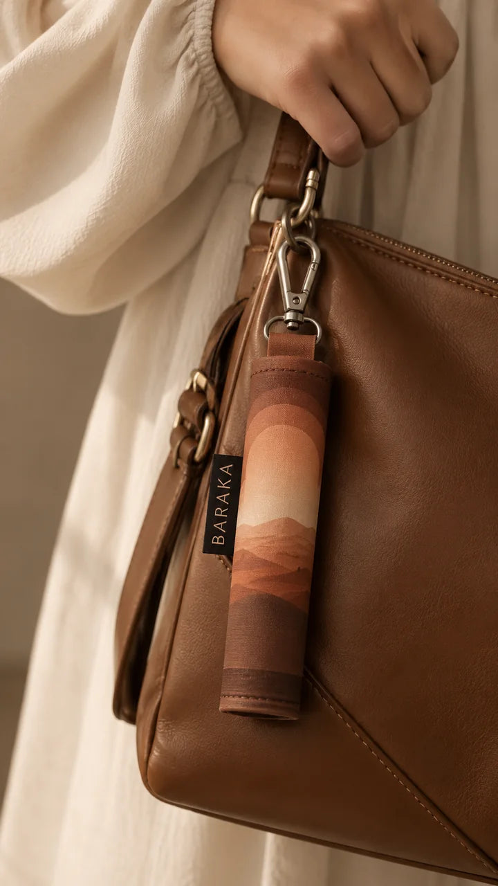 Le tapis nomade Baraka roulé, accroché au sac à main d'une femme